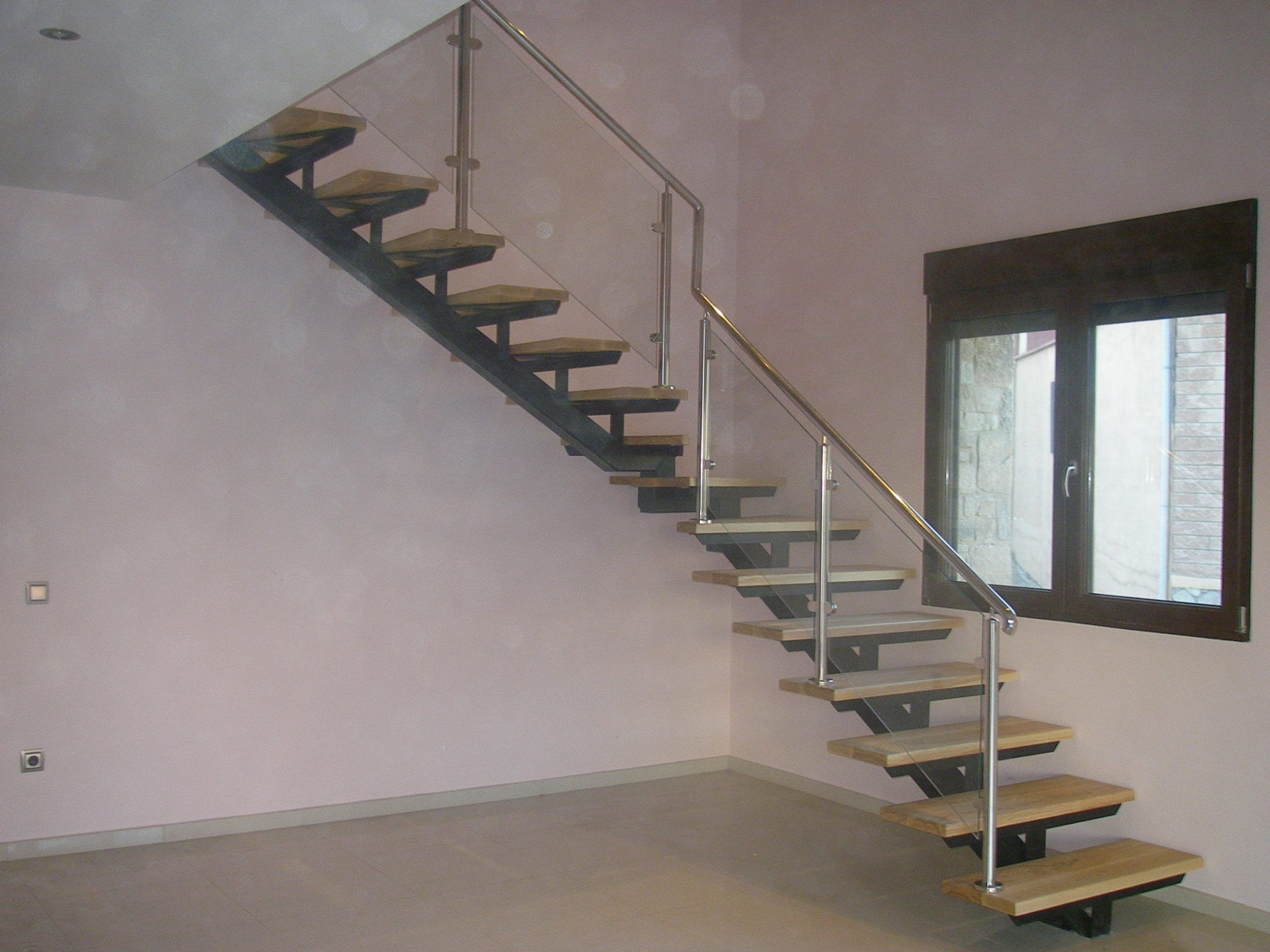 Escalera con pasos de madera y pasamanos en acero inxodable y cristal